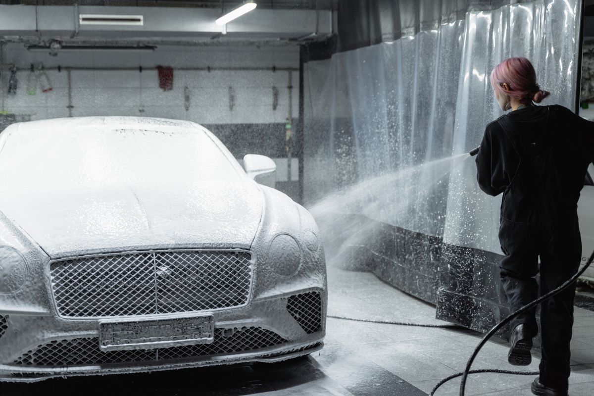 Professional pressure washing a vehicle before ceramic coating
